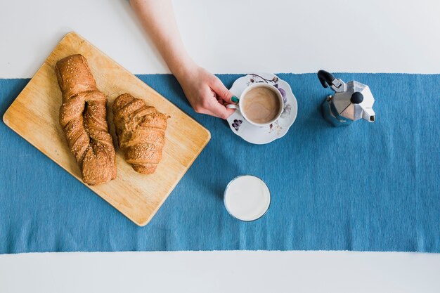 Mano de cultivo tomando café