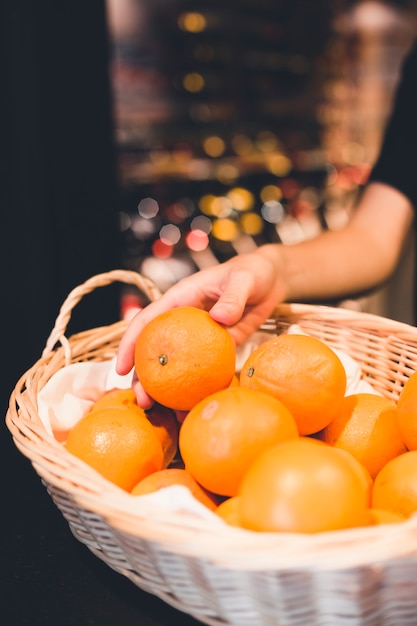 Mano de cultivo tomando naranjas de la cesta