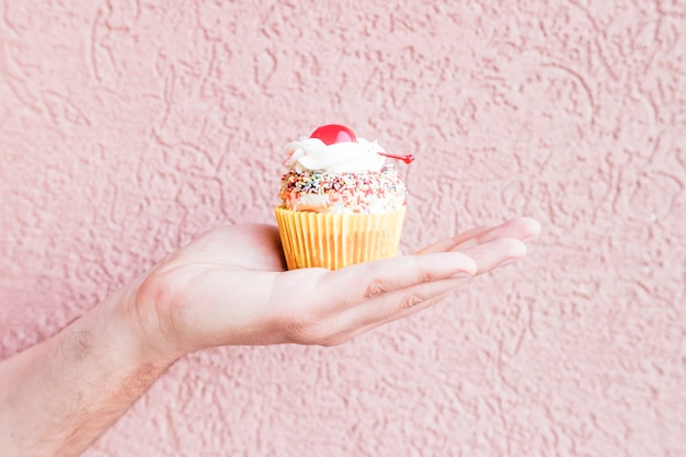 Foto gratuita mano de cultivos con cupcake