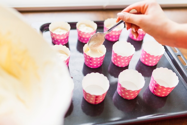 Mano de cultivos haciendo cupcakes