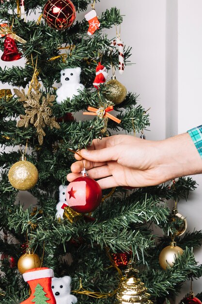 Mano decorando árbol de navidad