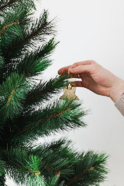 Mano decorando árbol de navidad