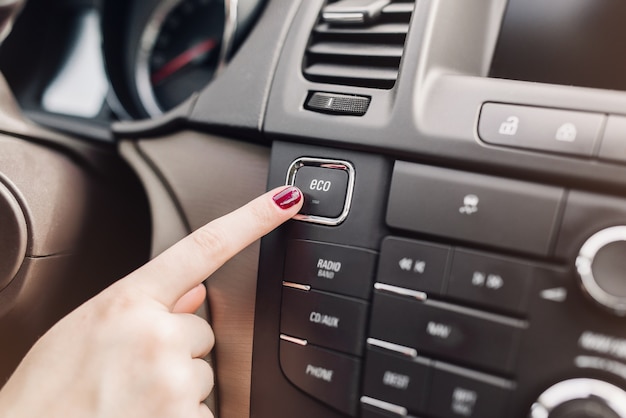 Mano dedo presionar botón Modo Eco en coche