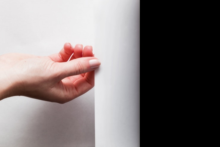Foto gratuito mano doblando un papel blanco