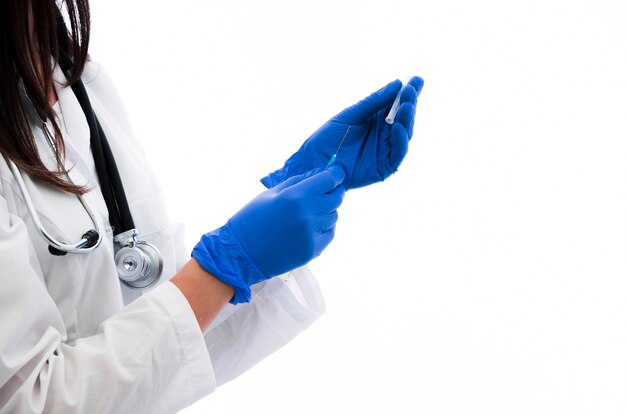 La mano del doctor en la jeringa que sostiene con guantes y la vacuna aisladas en el fondo blanco
