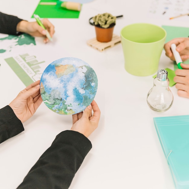 Mano de empresario sosteniendo el icono del planeta tierra