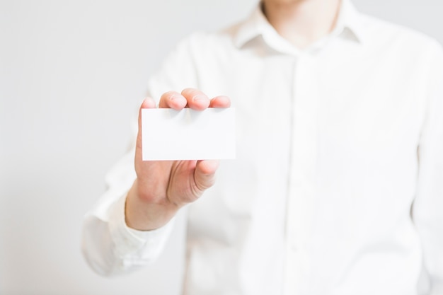 La mano del empresario sosteniendo la tarjeta de visita en blanco