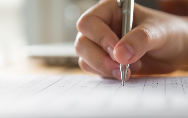 Mano escribiendo en un papel con un bolígrafo