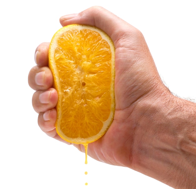 Mano exprimiendo una naranja | Foto Gratis