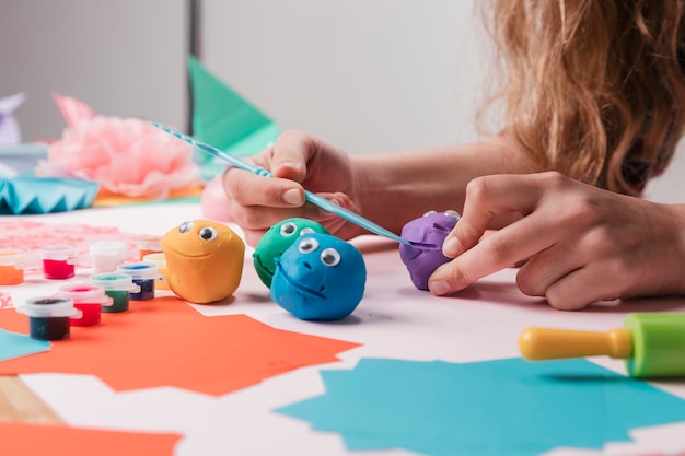 Mano femenina del artista que hace caras de la historieta usando el equipo del arte