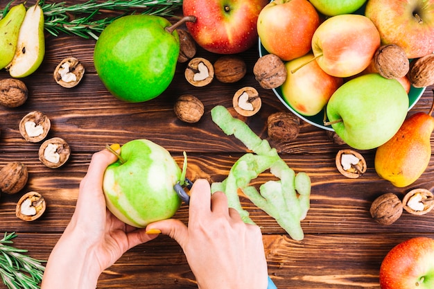 Foto gratuita mano femenina pelando manzana verde con pelador