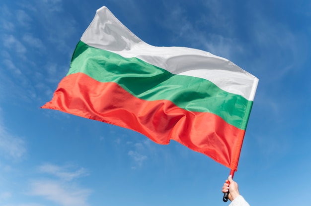 Mano femenina sosteniendo la bandera de tela de bulgaria
