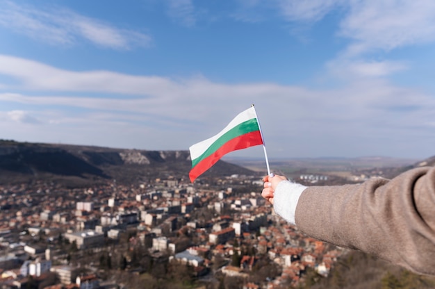 Mano femenina sosteniendo la bandera de tela de bulgaria