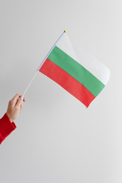 Mano femenina sosteniendo la bandera de tela de bulgaria
