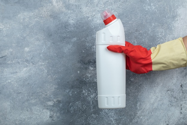 Foto gratuita mano femenina sosteniendo detergente en mármol.