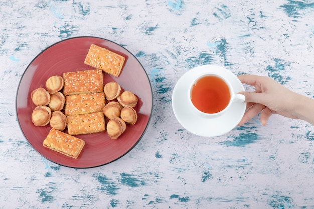 Foto gratuita mano femenina sosteniendo una taza de té con nueces de mantequilla con leche condensada.