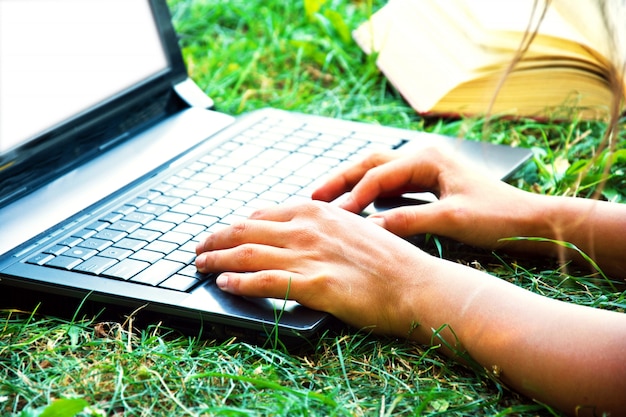 Foto gratuita mano femenina usando una computadora portátil al aire libre.