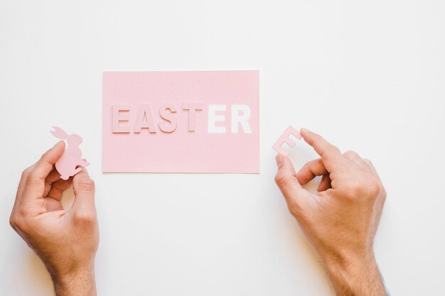 Mano haciendo la palabra de Pascua en papel