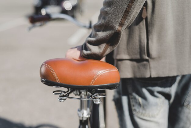 Mano del hombre en asiento de bicicleta