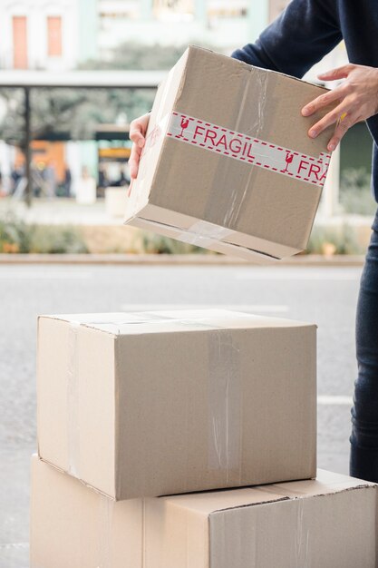 Mano del hombre de entrega que lleva el paquete