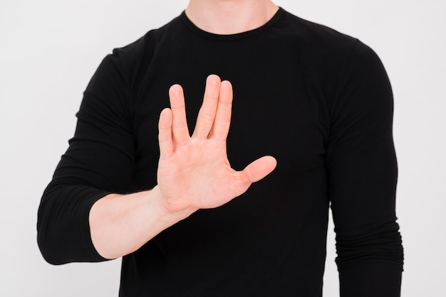 Mano del hombre mostrando gesto de parada contra el fondo blanco