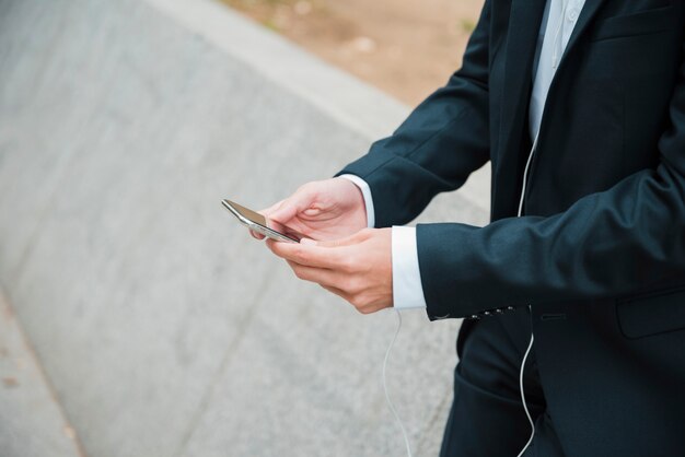 Mano de hombre de negocios mediante teléfono móvil