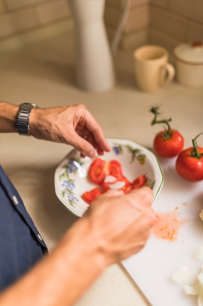 La mano del hombre preparando ensalada fresca