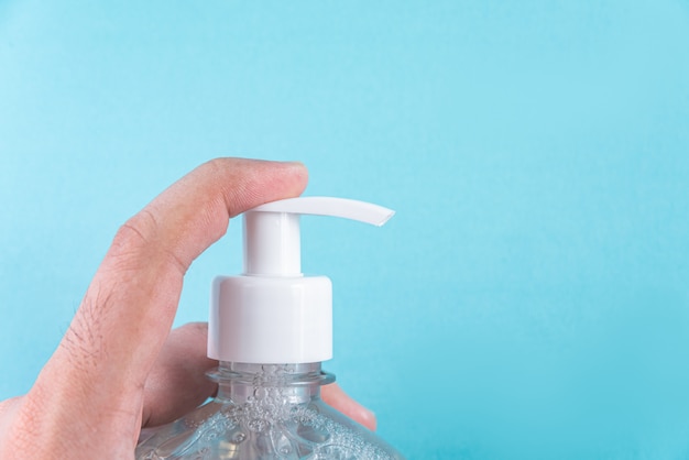 Mano del hombre en un recipiente con gel de alcohol