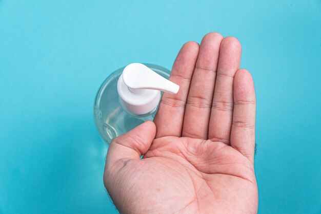 Mano del hombre en un recipiente con gel de alcohol