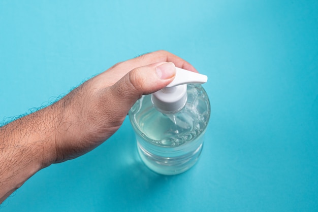 Mano del hombre en un recipiente con gel de alcohol