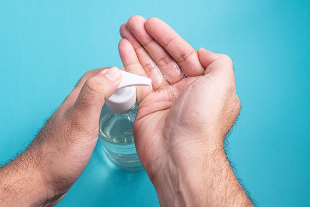 Mano del hombre en un recipiente con gel de alcohol