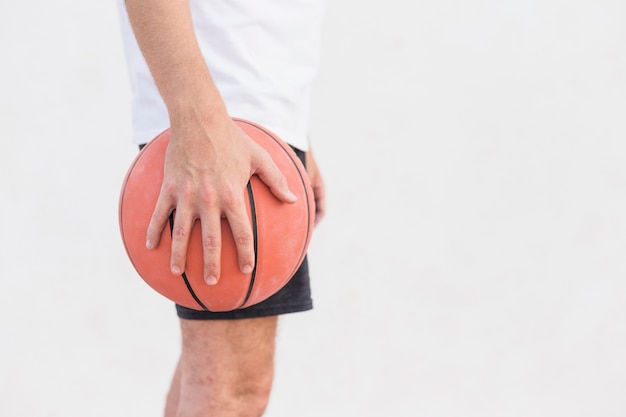 Mano del hombre sosteniendo baloncesto