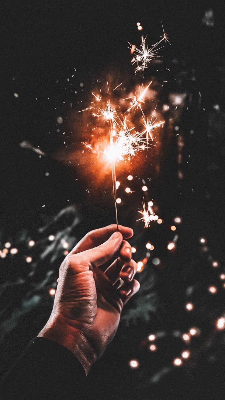 Foto gratuito la mano del hombre sosteniendo un palo brillante con un fondo oscuro