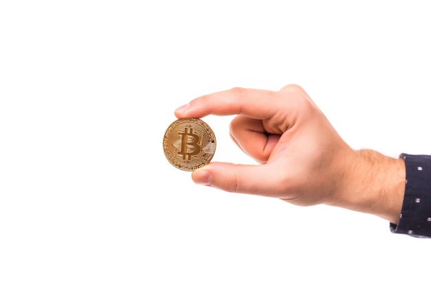 La mano del hombre sostiene un bitcoin de oro
