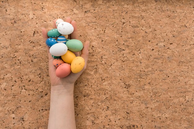 Mano con huevos de colores para el día de pascua