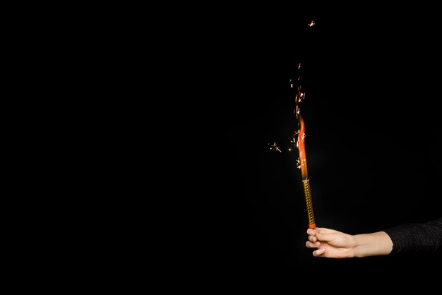 Mano humana con fuegos artificiales en llamas
