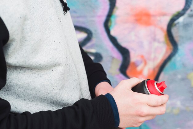 Mano humana sosteniendo la botella de spray