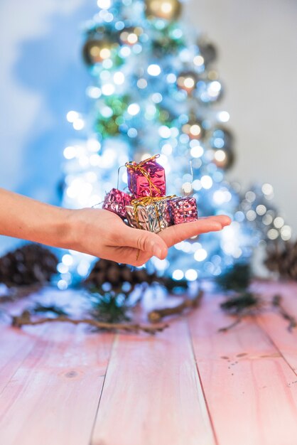 Mano humana sosteniendo cajas presentes brillantes