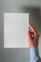 Foto gratuita mano humana sosteniendo el libro blanco en blanco