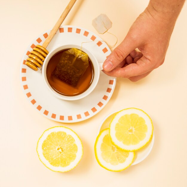 Mano humana sosteniendo una taza de té saludable