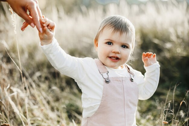 La mano de la madre sostiene a su pequeña hija por mano