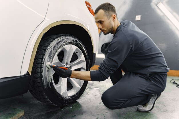 Mano masculina con esponja de espuma lavando coche