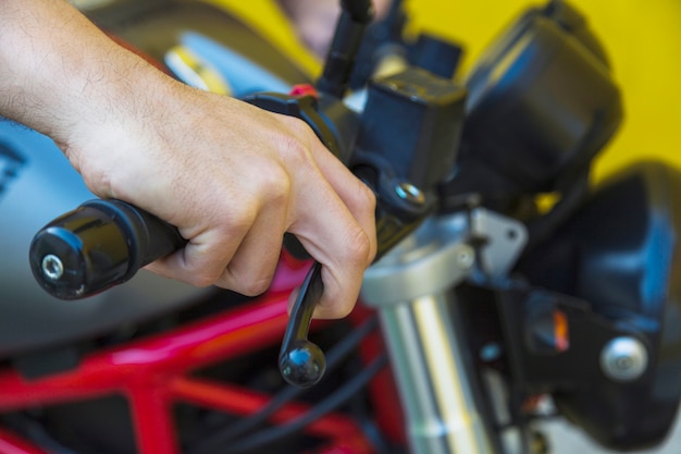 Mano masculina en el mango de la motocicleta