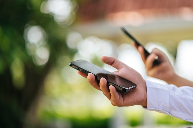 Mano masculina sosteniendo un teléfono inteligente, enfoque selectivo