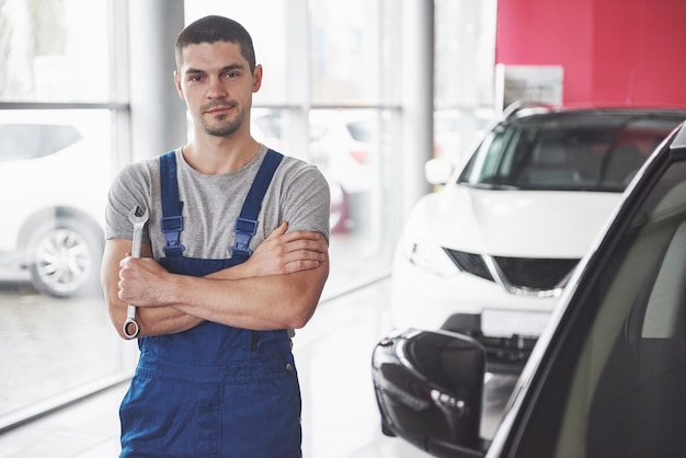 Mano de mecánico de automóviles con llave. Garaje de reparación de automóviles.