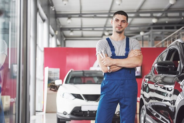 Mano de mecánico de automóviles con llave. Garaje de reparación de automóviles.