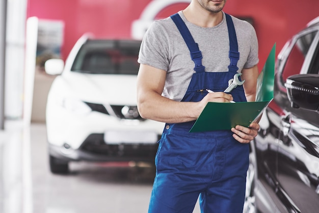 Mano de mecánico de automóviles con llave. Garaje de reparación de automóviles.