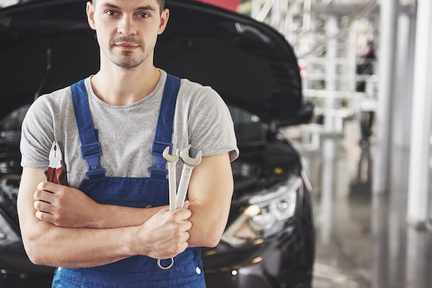 Foto gratuita mano de mecánico de automóviles con llave. garaje de reparación de automóviles.