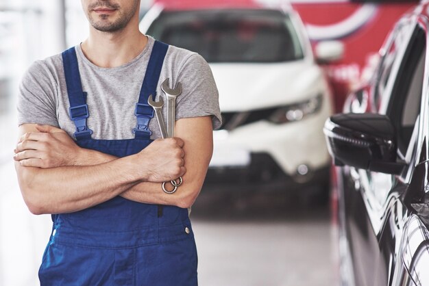 Mano de mecánico de automóviles con llave.
