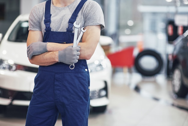 Mano de mecánico con llave. Garaje de reparación de automóviles